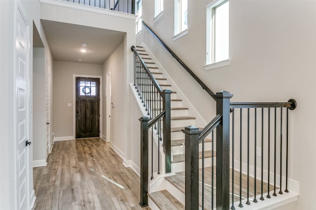 foyer entrance featuring a high ceiling, baseboards, and wood finished floors