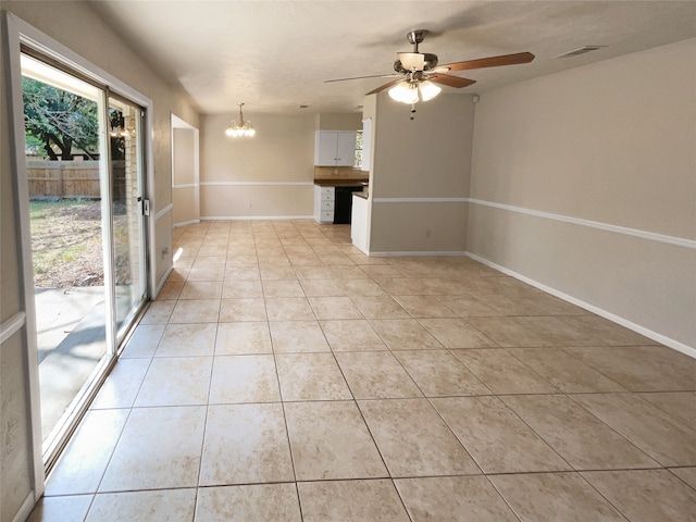 spare room with ceiling fan with notable chandelier and light tile patterned floors