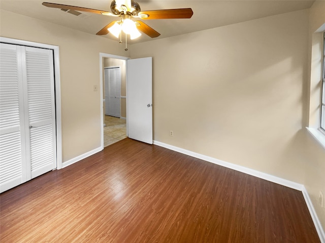 unfurnished bedroom with a closet, ceiling fan, and hardwood / wood-style flooring