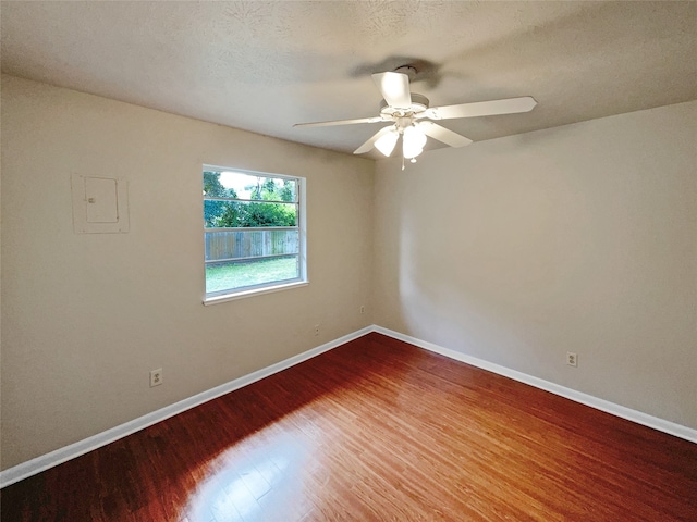 spare room featuring a textured ceiling, wood-type flooring, and ceiling fan