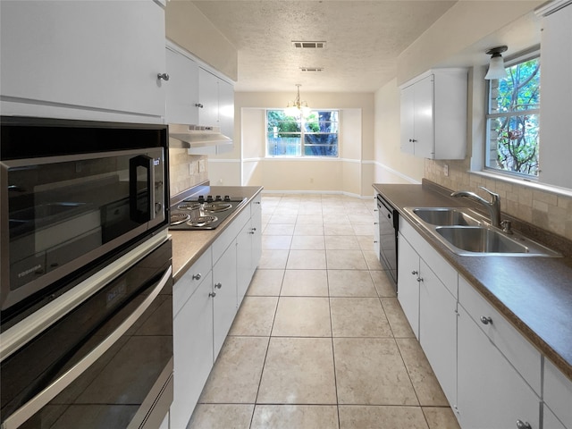 kitchen with decorative backsplash, stainless steel appliances, white cabinetry, and a wealth of natural light