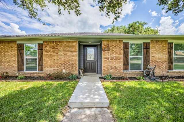 doorway to property featuring a lawn