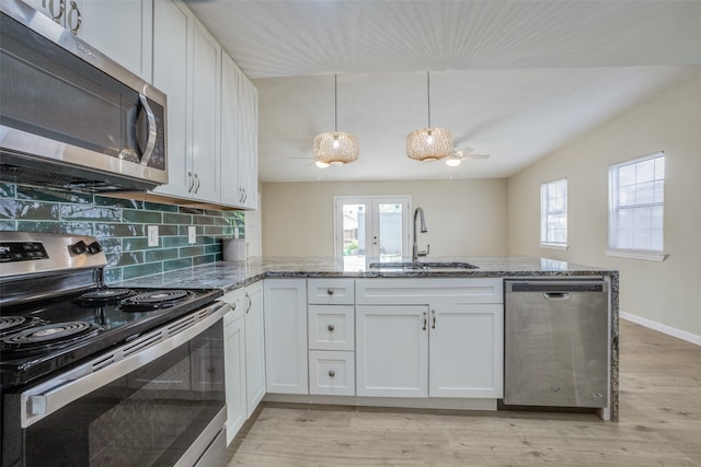 kitchen featuring white cabinetry, sink, stainless steel appliances, kitchen peninsula, and decorative light fixtures