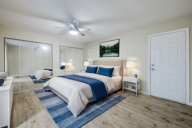 bedroom featuring multiple closets, ceiling fan, and light hardwood / wood-style floors