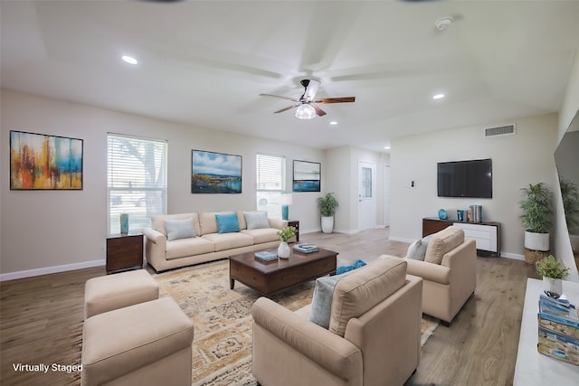 living room featuring ceiling fan and light hardwood / wood-style floors