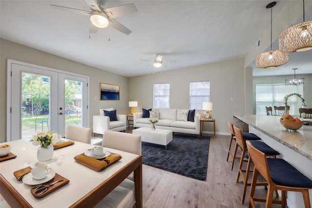 living room featuring french doors, light wood-type flooring, and ceiling fan