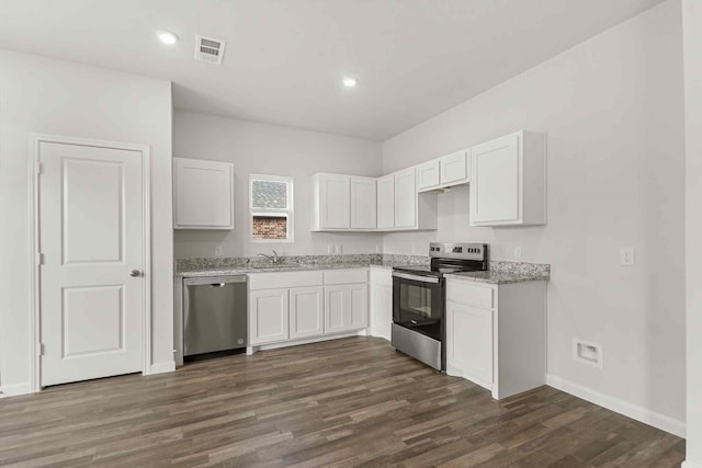 kitchen with white cabinetry, light stone counters, dark hardwood / wood-style floors, and appliances with stainless steel finishes