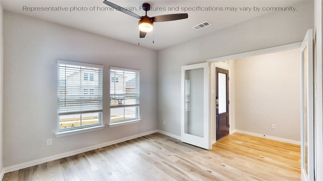 empty room with ceiling fan and light hardwood / wood-style flooring