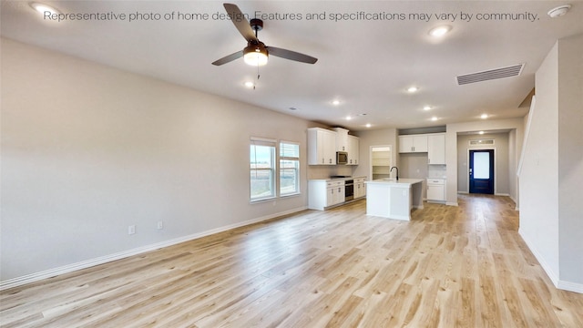 unfurnished living room with ceiling fan, light hardwood / wood-style flooring, and sink