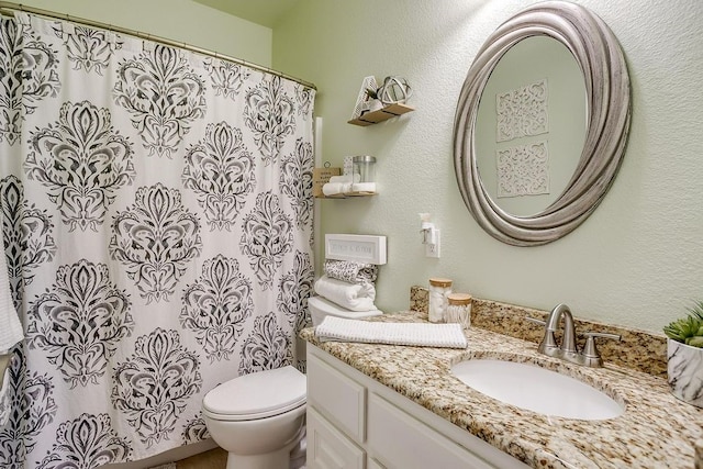 bathroom featuring walk in shower, vanity, and toilet