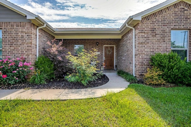 view of exterior entry featuring a yard