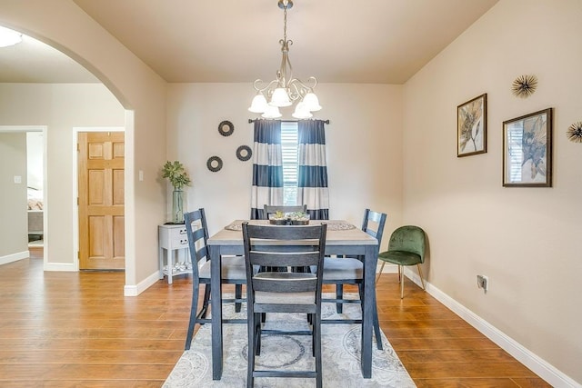 dining room with light hardwood / wood-style flooring and an inviting chandelier