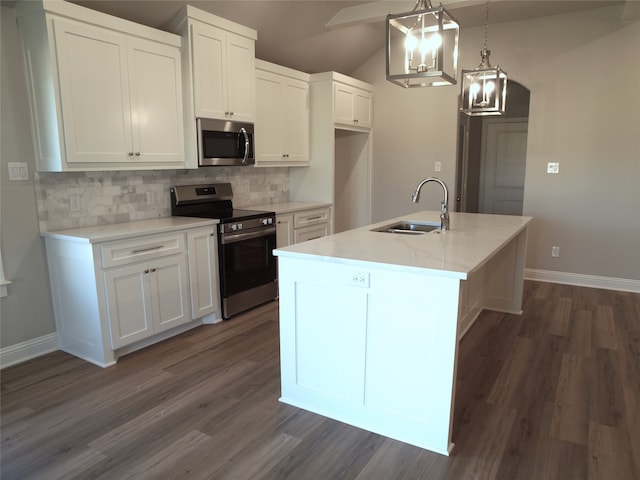 kitchen featuring white cabinetry, an island with sink, stainless steel appliances, decorative light fixtures, and sink