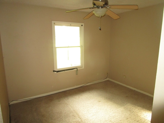 carpeted spare room featuring ceiling fan