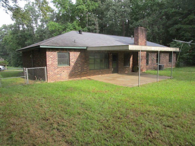 back of house featuring a lawn and a patio area