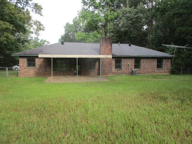 rear view of property with a lawn and a patio