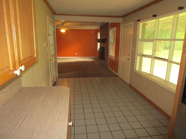 hall with crown molding and light tile patterned floors