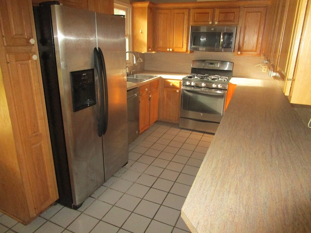 kitchen featuring light tile patterned floors, stainless steel appliances, and sink