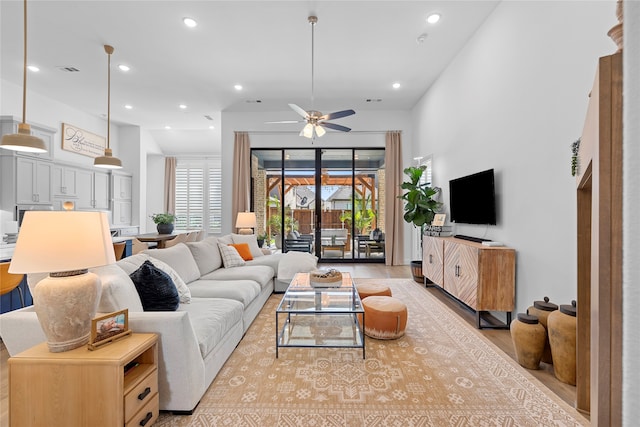 living room featuring light hardwood / wood-style floors and ceiling fan