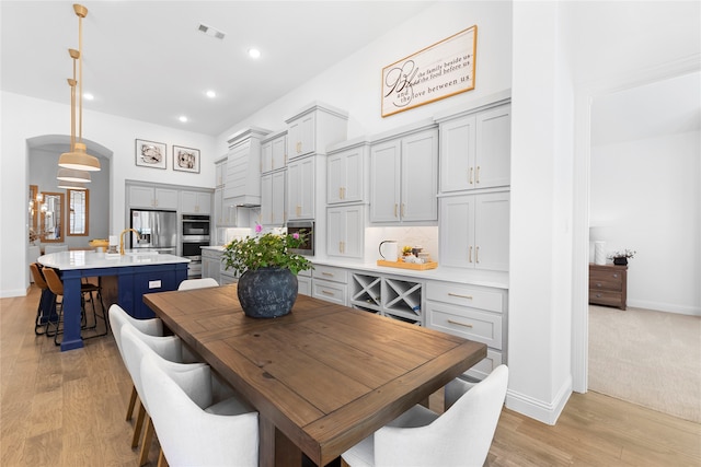 dining room with sink and light wood-type flooring