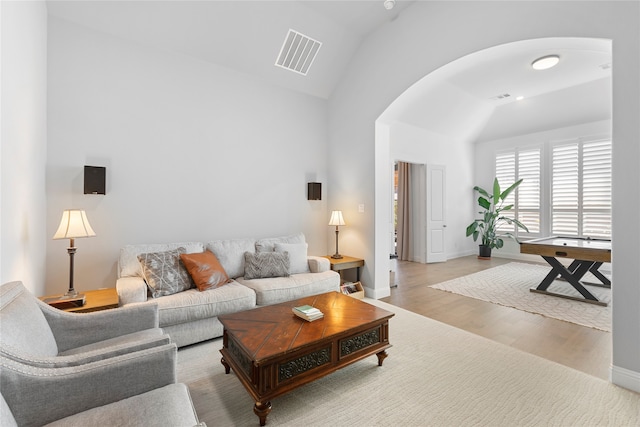 living room featuring light wood-type flooring and vaulted ceiling