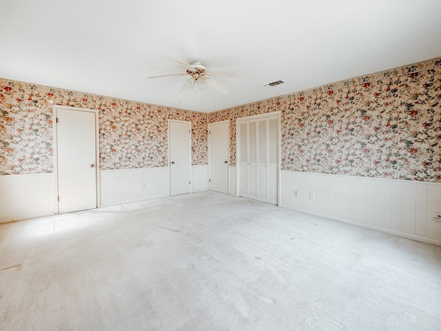 carpeted empty room featuring ceiling fan