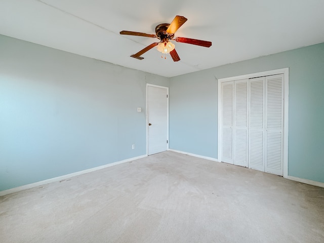 unfurnished bedroom with light carpet, a closet, and ceiling fan