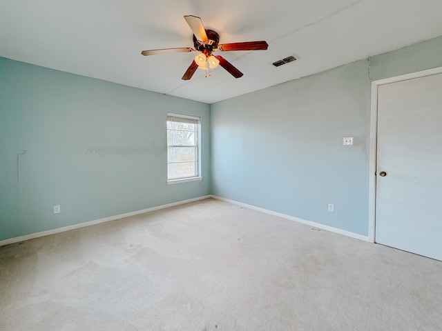 spare room with ceiling fan and light carpet