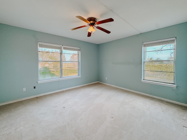 carpeted spare room with ceiling fan and a wealth of natural light