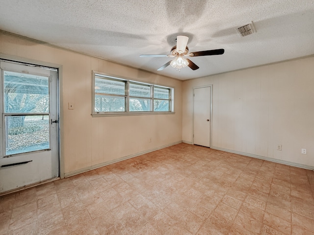 empty room with a textured ceiling and ceiling fan