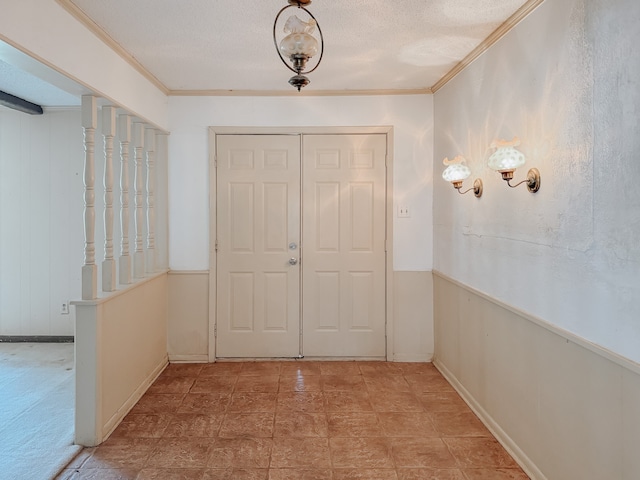 foyer entrance with wooden walls, a textured ceiling, and crown molding