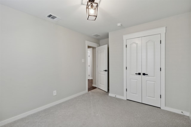 unfurnished bedroom featuring light colored carpet and a closet