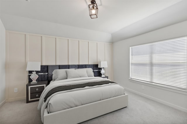 bedroom with light carpet and lofted ceiling