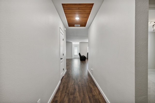 hallway with dark hardwood / wood-style flooring and wood ceiling