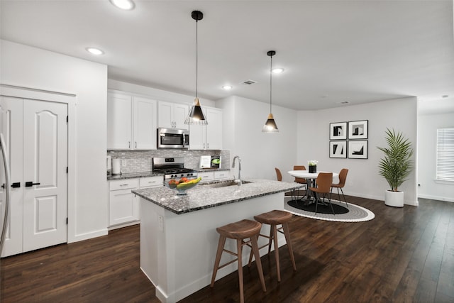 kitchen with pendant lighting, white cabinetry, sink, and stainless steel appliances