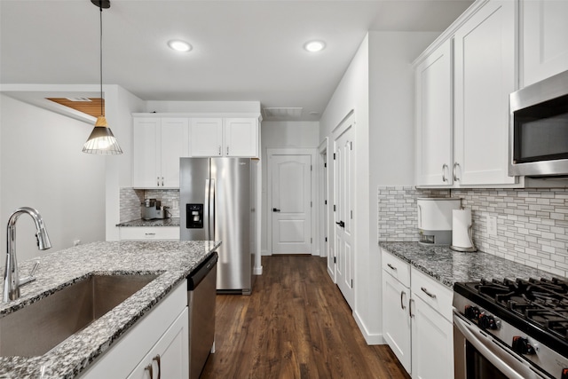 kitchen featuring stainless steel appliances, sink, white cabinets, dark hardwood / wood-style floors, and hanging light fixtures