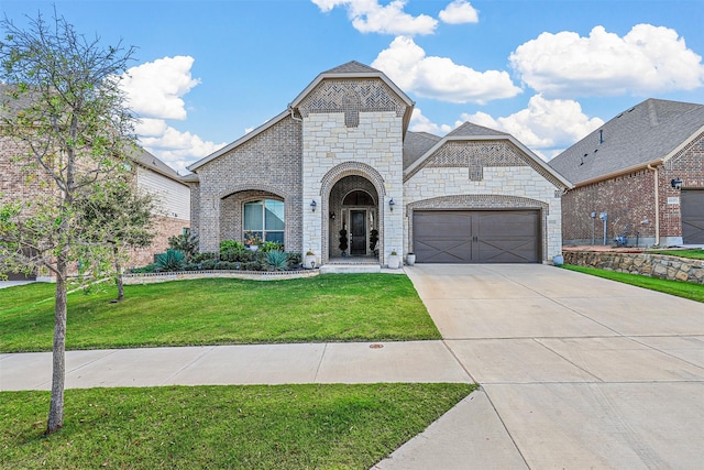 french country style house with a front yard and a garage