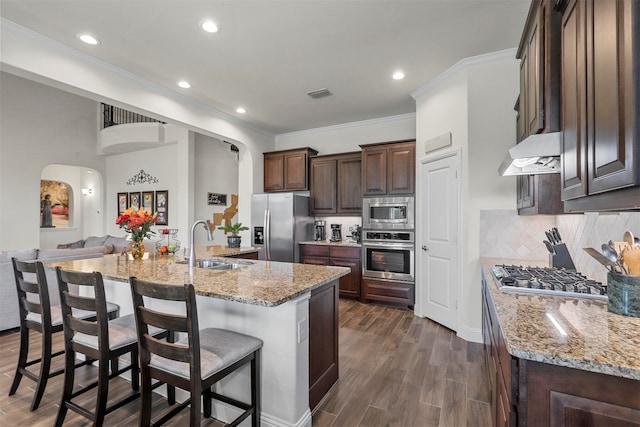 kitchen featuring light stone counters, a large island, appliances with stainless steel finishes, and sink