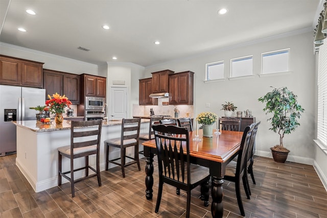 dining area with crown molding and dark hardwood / wood-style flooring