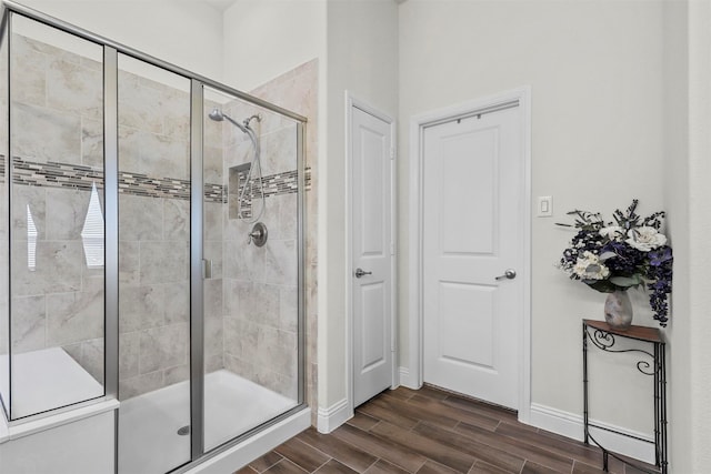 bathroom with a shower with shower door and hardwood / wood-style flooring