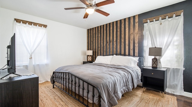 bedroom featuring light hardwood / wood-style flooring, ceiling fan, and multiple windows