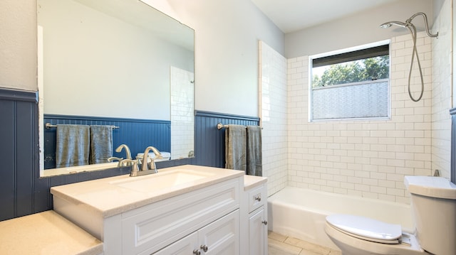 full bathroom featuring tiled shower / bath, vanity, and toilet