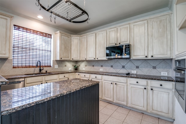 kitchen with stainless steel appliances, dark stone countertops, crown molding, and sink