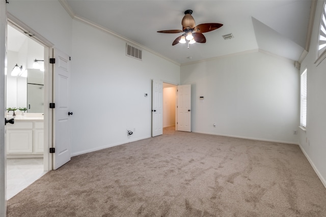 unfurnished bedroom featuring ceiling fan, light colored carpet, connected bathroom, and crown molding