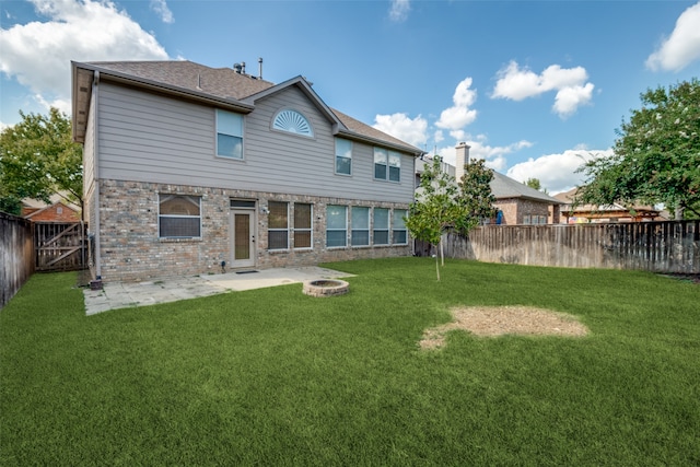 back of house featuring an outdoor fire pit, a yard, and a patio