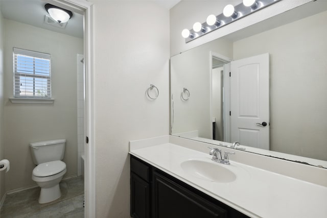 bathroom featuring tile patterned flooring, vanity, and toilet