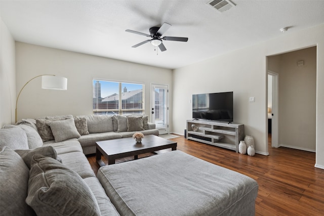 living room featuring ceiling fan and dark hardwood / wood-style flooring