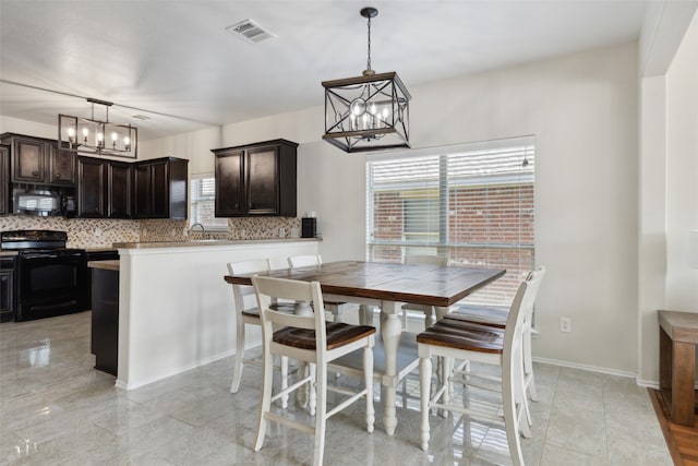 dining area with a chandelier and sink