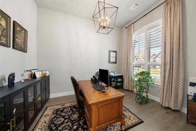 home office featuring dark wood-type flooring and an inviting chandelier