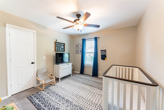 bedroom with carpet floors, ceiling fan, and a nursery area